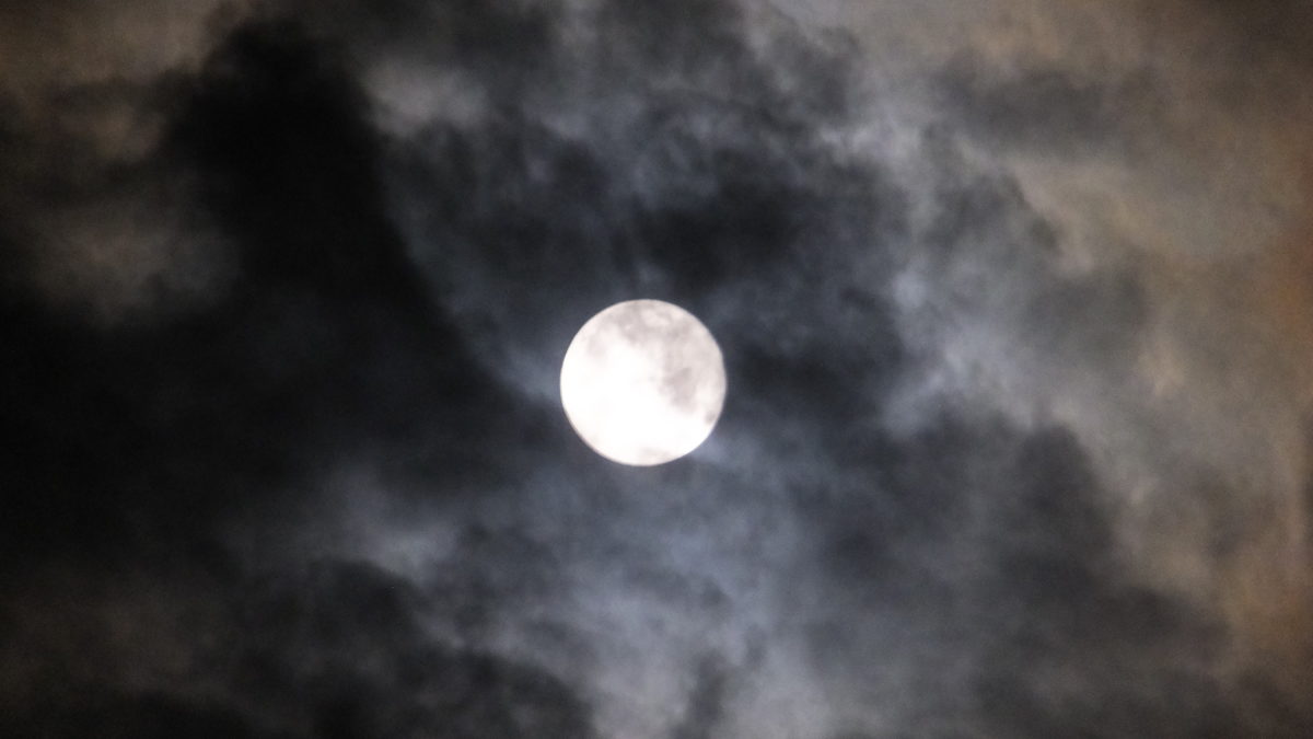 Image of the Moon surrounded by clouds at night